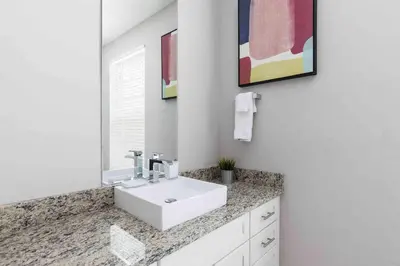 a bathroom with a white sink and a mirror at Chic 4 Bedroom at Summerville Minutes from Disney in Orlando