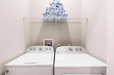 two white washing machines in a room with a christmas tree at Chic 4 Bedroom at Summerville Minutes from Disney in Orlando