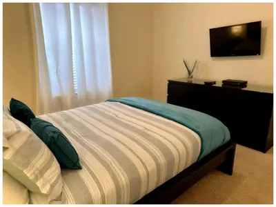 a bedroom with a bed with a television on the wall at Home 4Bed in Storey Lake with Private Pool in Kissimmee