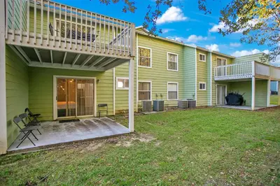 a green house with a deck and a yard at Familiar Retreat with Resort Access Near Disney in Kissimmee