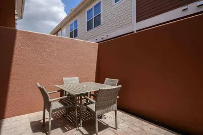 a table and chairs sitting next to a building at Stylish 4Bed Townhome at Summerville Near Disney in Orlando