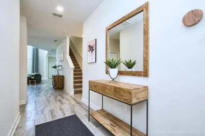 a hallway with a mirror and a table with plants at Chic Home Themed Bedrooms Game Room Best Spot in Kissimmee
