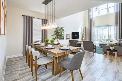 a dining room and living room with a table and chairs at Chic Home Themed Bedrooms Game Room Best Spot in Kissimmee