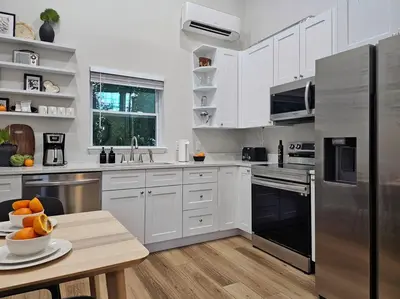 a kitchen with white cabinets and a stainless steel refrigerator at The Catherine - 1 mile to downtown - 2 King beds - Sleeps 5 in Orlando