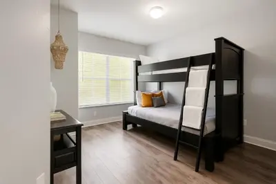 a bedroom with a bunk bed and a desk at Disney-Area 3BR Townhome | Sleeps 9 | Pool + Gym in Kissimmee