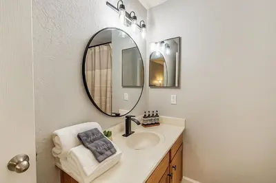 a bathroom with a sink and a mirror at Disney-Area 3BR Townhome | Sleeps 9 | Pool + Gym in Kissimmee