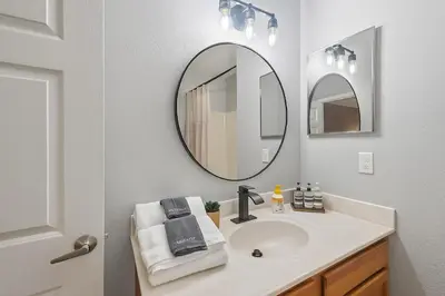 a bathroom with a sink and a mirror at Disney-Area 3BR Townhome | Sleeps 9 | Pool + Gym in Kissimmee