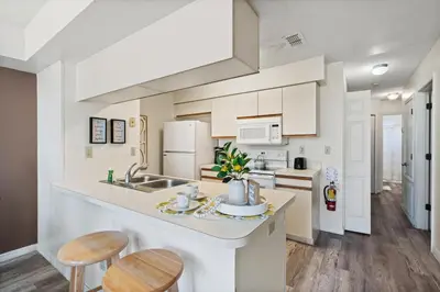 a kitchen with white cabinets and a counter with stools at 2721 North Poinciana #164 in Kissimmee