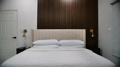 a bedroom with a bed with white sheets and pillows at Luxury home with Pool & 6 Beds near Disney in Kissimmee