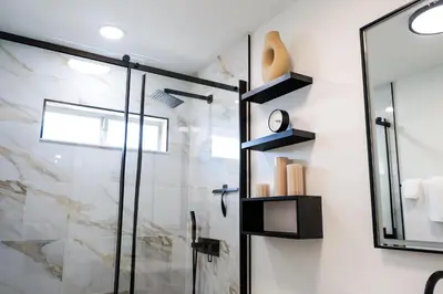 a bathroom with a shower and a glass door at Luxury home with Pool & 6 Beds near Disney in Kissimmee