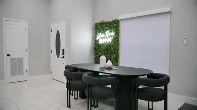 a dining room with a black table and chairs at Luxury home with Pool & 6 Beds near Disney in Kissimmee