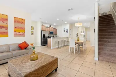 a living room and kitchen with a couch and a table at 5 BD 4 BA Private Pool Paradise Palms (8839 CP) in Kissimmee