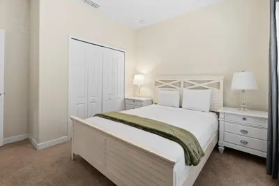 a white bedroom with a large bed and two night stands at 5 BD 4 BA Private Pool Paradise Palms (8839 CP) in Kissimmee