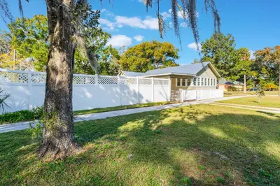 a house with a white fence and a tree at Sanford's Haven, 3 Bedroom, Sleeps 7 in Sanford