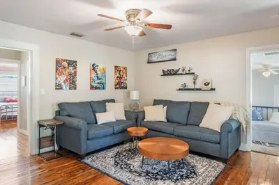 a living room with two blue couches and a ceiling fan at Sanford's Haven, 3 Bedroom, Sleeps 7 in Sanford