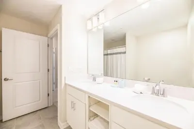 a bathroom with two sinks and a large mirror at Chic 2Bed Condo at Storey Lake Mickey Room in Kissimmee