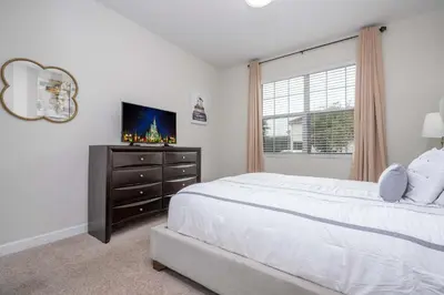 a bedroom with a bed and a dresser and a window at Home 6Bed , Themed Rooms, Game Room, Storey Lake in Kissimmee