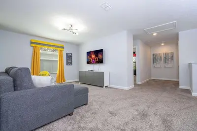 a living room with a couch and a tv at Home 6Bed , Themed Rooms, Game Room, Storey Lake in Kissimmee