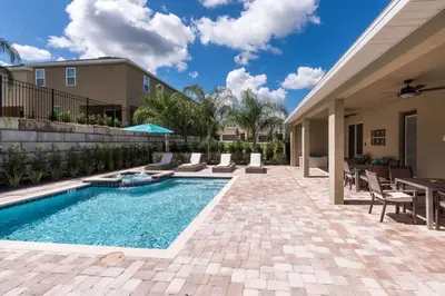 a swimming pool in a yard with chairs and a table at Fabulous Disney Vacation Home in Orlando
