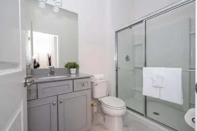 a white bathroom with a toilet and a shower at The Best Paradiso Vacation House in Orlando