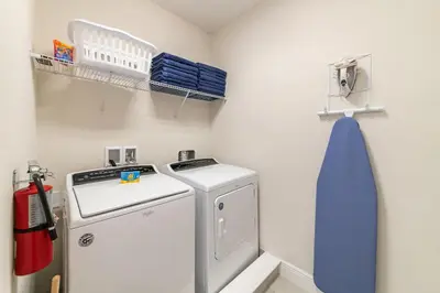 a laundry room with a washing machine and a blue towel at Fantastic Disney Vacation W Pool and Movie Theater in Orlando