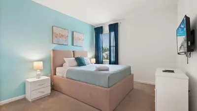 a bedroom with a bed and a television in it at Summer Sale - Beautiful 6BR Home with Private Pool! in Kissimmee