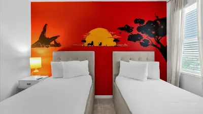 two beds in a room with a red wall at Summer Getaway in FL - 6BR Home with Private Pool! in Kissimmee