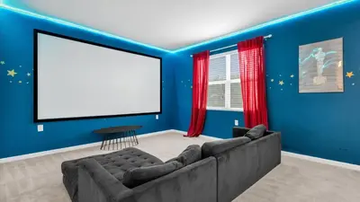 a living room with a couch and a blank screen at Summer Getaway in FL - 6BR Home with Private Pool! in Kissimmee