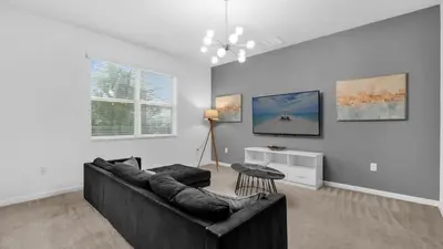 a living room with a couch and a table at Summer Getaway in FL - 6BR Home with Private Pool! in Kissimmee