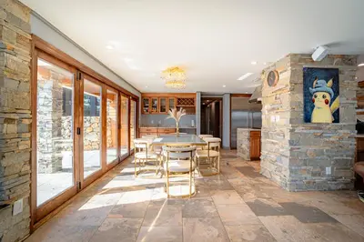 a dining room with a stone wall and a table and chairs at Luxury Lakefront 100,000 Gal Pool Villa - Orlando in Orlando