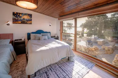a bedroom with a bed and a large window at Luxury Lakefront 100,000 Gal Pool Villa - Orlando in Orlando