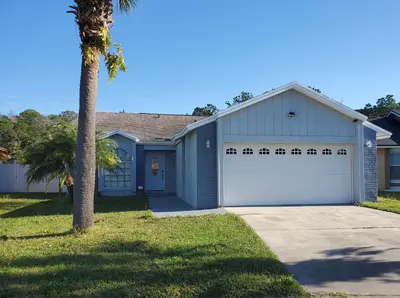 a white garage with a palm tree in front of it at Wonderful Villa with swimming pool, near Orlando attractions in Kissimmee