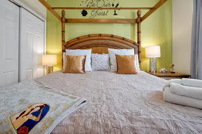 a bedroom with a large bed with a wooden headboard at Personally Designed Home w/ Pool, Game Room near Disney in Orlando