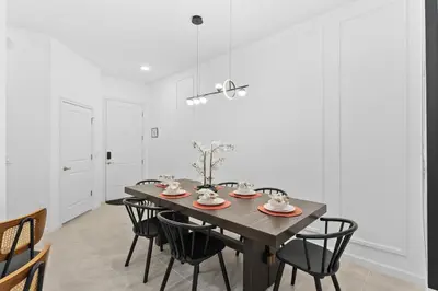 a dining room with a wooden table and black chairs at Lux 5BR Home, Game Room, 4 Suites & Private Pool in Orlando
