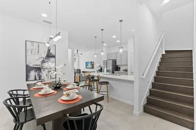 a dining room with a table and chairs and a staircase at Lux 5BR Home, Game Room, 4 Suites & Private Pool in Orlando