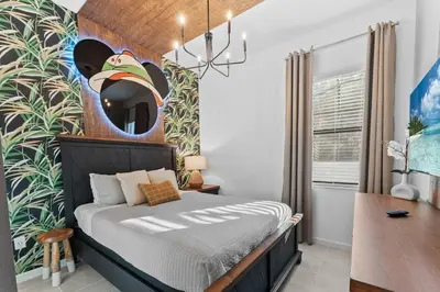 a bedroom with a bed with a mickey mouse mural at Lux 5BR Home, Game Room, 4 Suites & Private Pool in Orlando