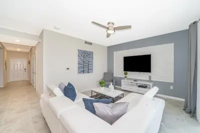 a living room with a white couch and a flat screen tv at 3111-102RD CONDO 2 BEDS/2 BATHS (SANITIZED) in Kissimmee