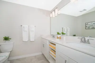 a white bathroom with a sink and a toilet at 3111-102RD CONDO 2 BEDS/2 BATHS (SANITIZED) in Kissimmee