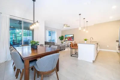 a dining room and living room with a table and chairs at 2585LA TOWNHOUSE 4 BEDROOMS & 3 BATHROOMS + POOL in Kissimmee