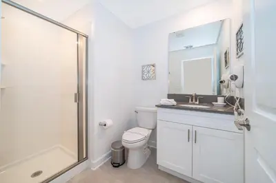 a bathroom with a toilet and a sink and a shower at 4415RH TOWNHOUSE 5 BEDROOMS & 4 BATHROOMS + POOL in Kissimmee
