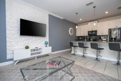 a living room with a flat screen tv on a wall at 4337 QS - Charming Hideaway in Kissimmee