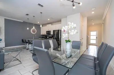 a dining room and kitchen with a glass table and chairs at 4337 QS - Charming Hideaway in Kissimmee