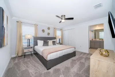 a bedroom with a bed and a ceiling fan at 4220AA TOWNHOUSE 4 BEDROOM 3 BATHS + PRIVATE POOL in Kissimmee