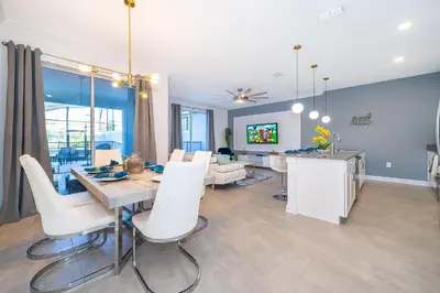 a dining room and living room with a table and chairs at 4435LT TOWNHOUSE 4 BEDROOMS & 3 BATHROOMS + POOL in Kissimmee