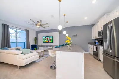 a kitchen and living room with a couch and a table at 4435LT TOWNHOUSE 4 BEDROOMS & 3 BATHROOMS + POOL in Kissimmee