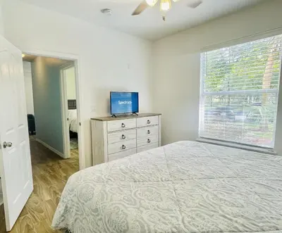 a bedroom with a bed and a window and a dresser at Cozy Condo Minutes Away From Disney in Kissimmee