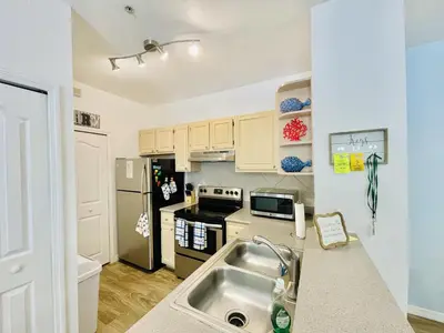 a kitchen with a sink and a refrigerator at Cozy Condo Minutes Away From Disney in Kissimmee