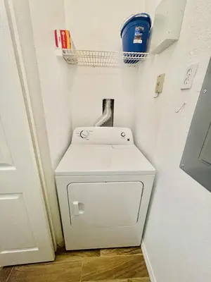 a small white washer and dryer in a room at Cozy Condo Minutes Away From Disney in Kissimmee