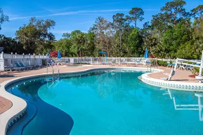 a swimming pool at a resort with blue water at Barefoot'n Resort Kissimmee Orlando in Orlando