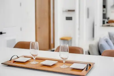 a wooden tray with two wine glasses on a table at Florida HappyNest Secluded Luxury Guesthouse in Kissimmee